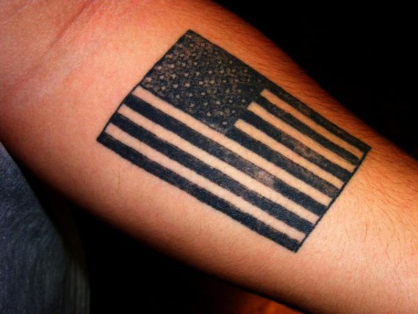 Dark American Flag Tattoo On Forearm